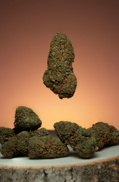 Weed nugs dropping from the air onto a piece of wood